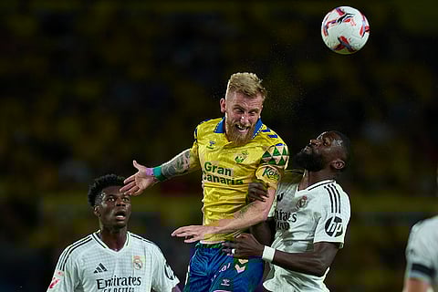 La liga 2024-25: Las Palmas' Oliver McBurnie, center, heads the ball challenged by Real Madrid's Antonio Rudiger